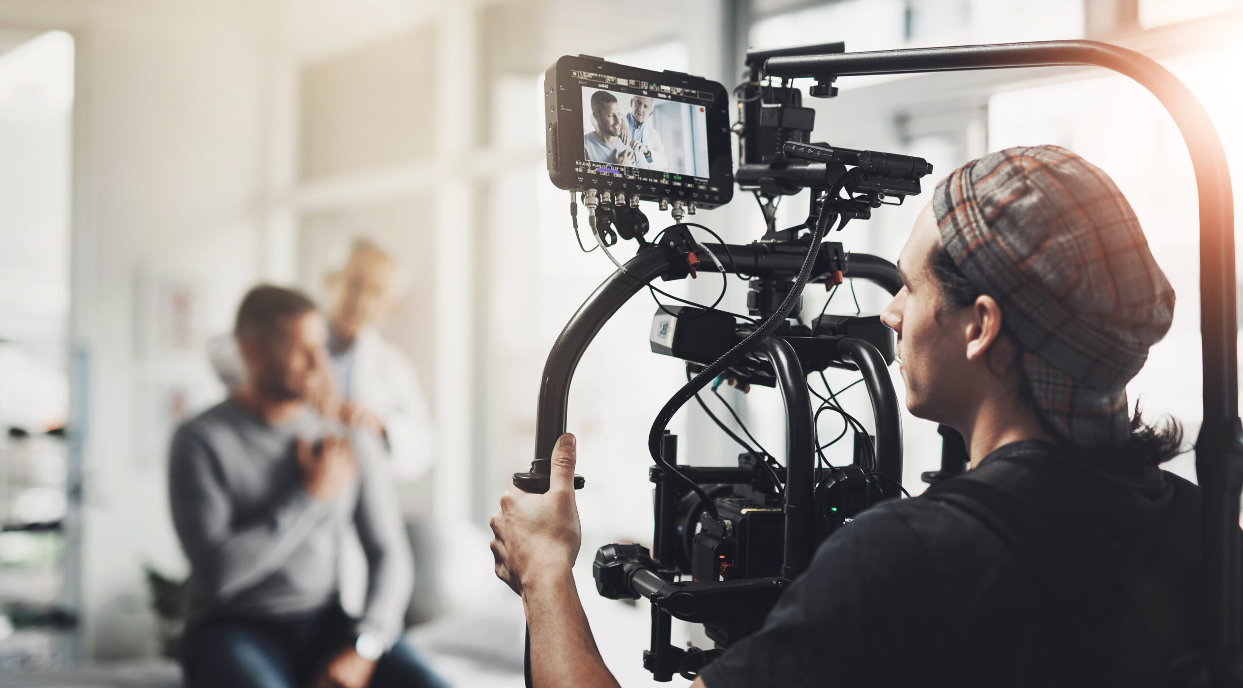 Production, shooting and man with camera in recording for healthcare, commercial and creative project. Hospital, photographer and people with content creation for medical, service and consultation.
